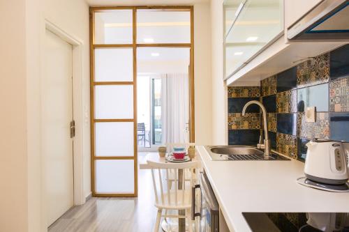 a kitchen with a counter with a sink and a counter top at Meltemi Coast Suites in Rethymno Town