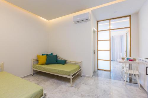 a room with a couch with colorful pillows on it at Meltemi Coast Suites in Rethymno Town