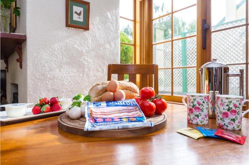 a table with a plate of eggs and vegetables on it at Country Pleasures Bed and Breakfast in Angaston