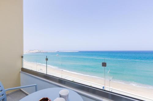 a room with a view of the beach and the ocean at Meltemi Coast Suites in Rethymno Town