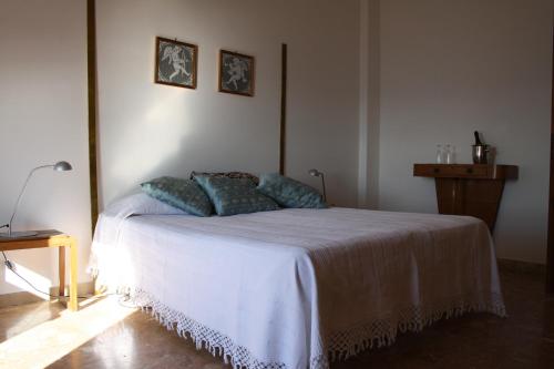 ターラントにあるCasa Dei Ricciのベッドルーム(白いベッド、青い枕付)