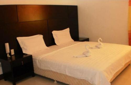 two swans sitting on a bed in a bedroom at Asia Novo Boutique Hotel - Kalibo in Kalibo