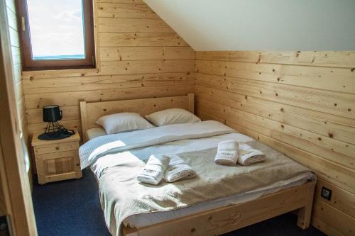 a bedroom with a bed with two pairs of shoes on it at Solankowe Zacisze in Baryczka