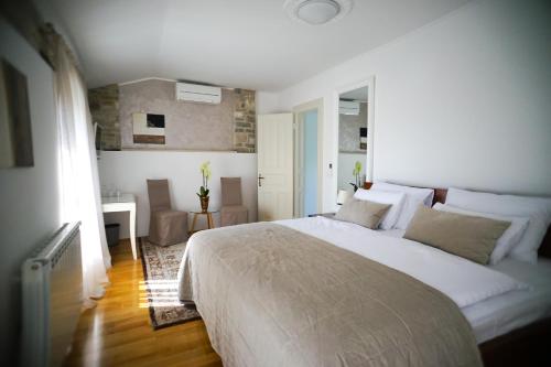 ein Schlafzimmer mit einem großen weißen Bett und einem Schreibtisch in der Unterkunft Stancija Ruseti in Oprtalj