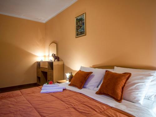 a bedroom with a large bed with orange walls at Apartments Stella del Mare in Risan