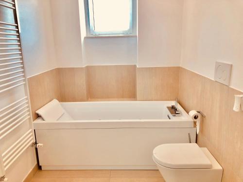 a bathroom with a tub and a toilet at Attico Palazzo di Vetro in Luino