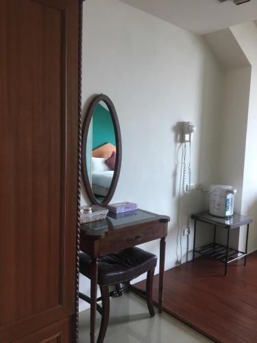 a dressing table with a mirror and a stool at Harmony Ocean Hotel in Kenting