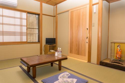 京都市にあるRyokan Hinomoto Kyoto Kawaramachiのリビングルーム(テーブル、テレビ付)