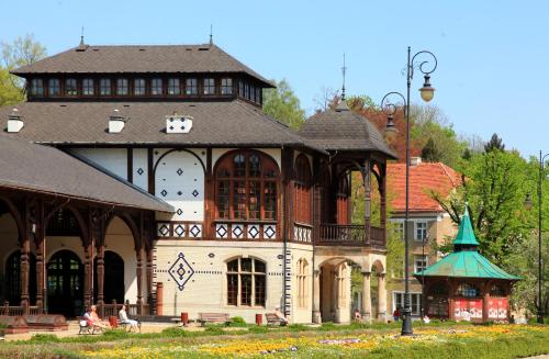a large building with a gazebo in a park at Hotel Camelot in Szczawno-Zdrój