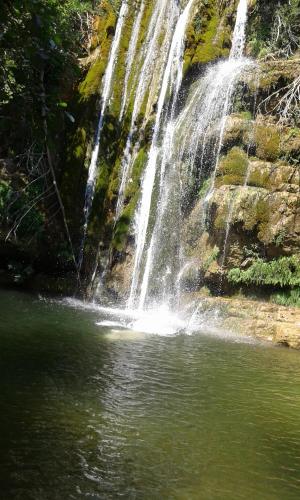 a waterfall in front of a pool of water at B&B Villa Filetta in Marsia
