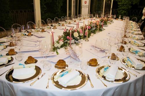 
a white table topped with white plates filled with food at Palazzo Gattini Luxury Hotel in Matera
