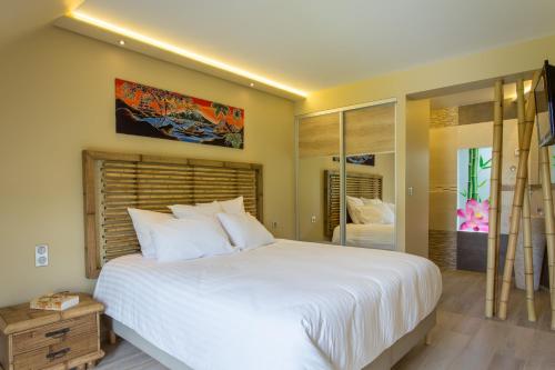 a bedroom with a large white bed and a large window at Maison Indigo in Athie