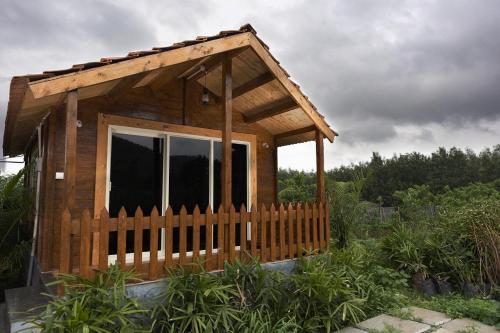 a small wooden cabin with a wooden fence at Trippr Chikkamagaluru in Chikmagalūr