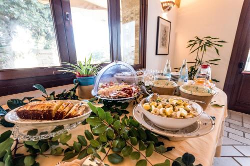 a table with many plates of food on it at Masseria Ruri Pulcra in Patù