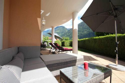 a living room with a couch and an umbrella at Villa Wellness Homes in Mötz