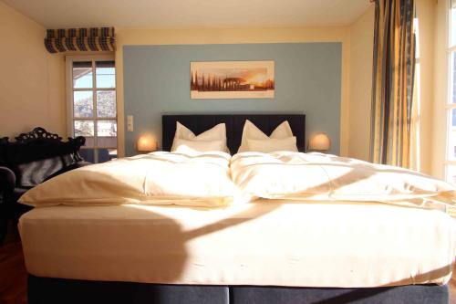 a bedroom with a large bed with white sheets at Villa Wellness Homes in Mötz