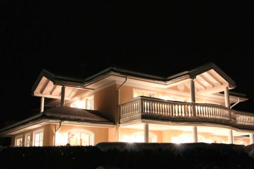 a large house with a balcony at night at Villa Wellness Homes in Mötz