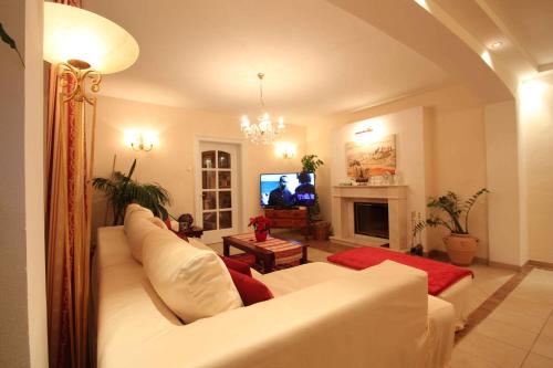 a living room with a white couch and a tv at Villa Wellness Homes in Mötz