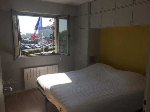 une chambre avec un lit blanc et une fenêtre dans l'établissement Appartement à Trouville sur mer, à Trouville-sur-Mer