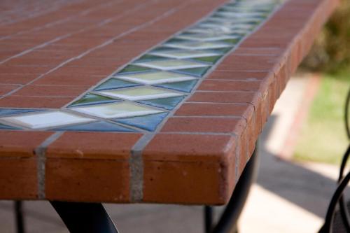 a brick bench with a blue and white tile on it at Villa Wellness Homes in Mötz