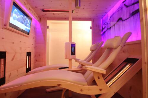 a room with three chairs and a tv at Villa Wellness Homes in Mötz