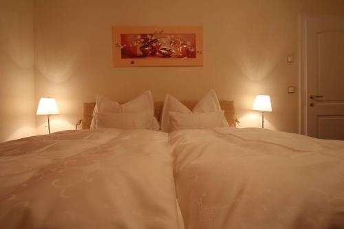 a white bed with white sheets and pillows at Villa Wellness Homes in Mötz