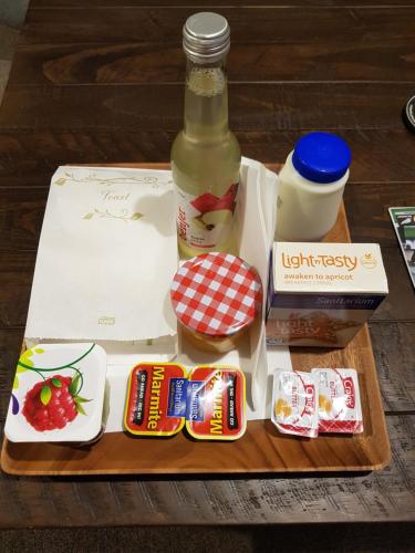 a wooden tray with a bottle of alcohol and other foods at Beechwood Boutique Accommodation in Dunedin