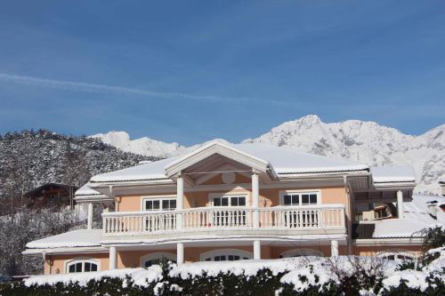 a house covered in snow with mountains in the background at Villa Wellness Homes in Mötz