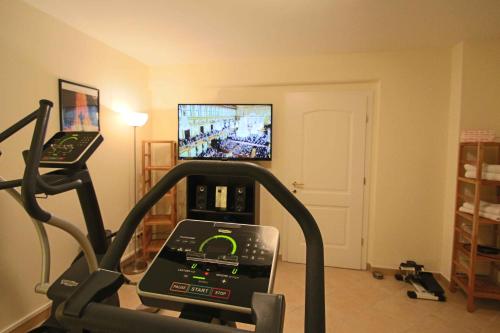 a room with a gym with a treadmill and a tv at Villa Wellness Homes in Mötz