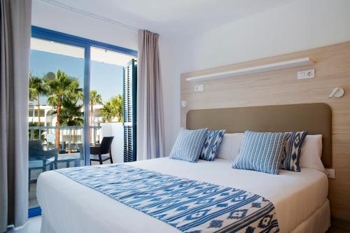 1 dormitorio con 1 cama grande y balcón en Aparthotel Pierre & Vacances Mallorca Cecilia en Puerto Colom