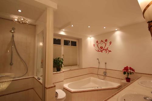 a bathroom with a tub and a toilet and a sink at Villa Wellness Homes in Mötz
