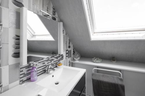 a bathroom with a sink and a mirror and a window at Chez Marie et Jean François in Dol-de-Bretagne