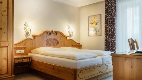 a bedroom with a bed with a wooden head board at Landgasthof Apfelbeck in Mamming