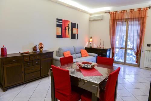 a living room with a table and red chairs at Anagnina Home in Rome