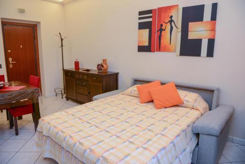 a bedroom with a bed with orange pillows on it at Anagnina Home in Rome