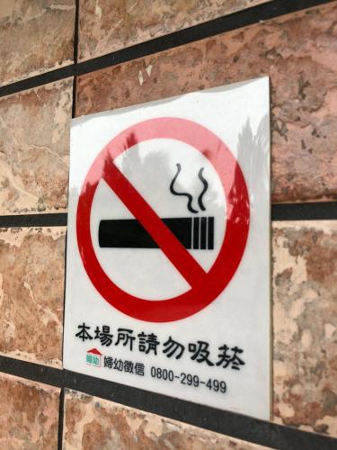a no smoking sign on a brick wall at Chinshan Villa in Zhongzheng