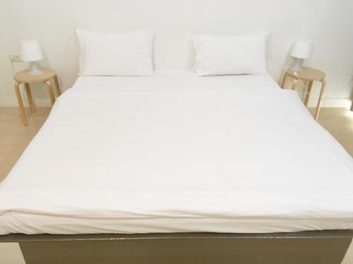 Elle comprend un grand lit avec des draps et des oreillers blancs. dans l'établissement A-Port, à Lat Krabang