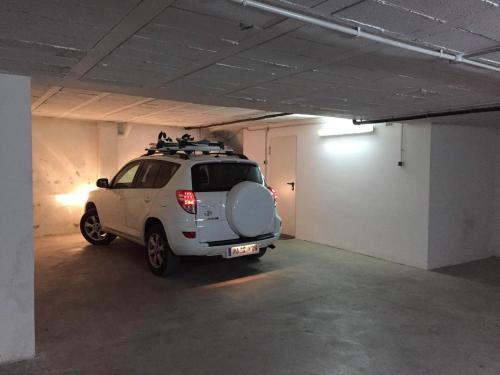 a white suv parked in a parking garage at Casa adosada con piscina en Isòvol in Isóbol