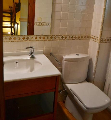 a bathroom with a white toilet and a sink at Casa adosada con piscina en Isòvol in Isóbol