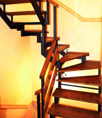 a wooden spiral staircase in a room with a wall at Casa adosada con piscina en Isòvol in Isóbol