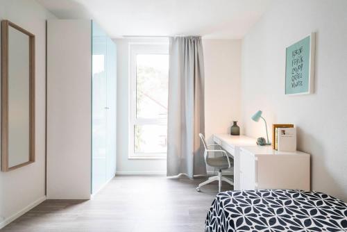 Schlafzimmer mit einem Bett, einem Schreibtisch und einem Fenster in der Unterkunft ApartWehr Business&Ferien Apartment Grün in Wehr