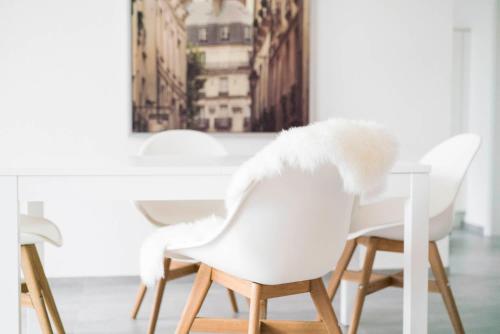 een eetkamer met witte stoelen en een tafel bij ApartWehr Business&Ferien Apartment Grün in Wehr