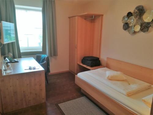 ein Hotelzimmer mit einem Bett und einem Schreibtisch in der Unterkunft Hotel Landgasthof Euringer in Oberstimm