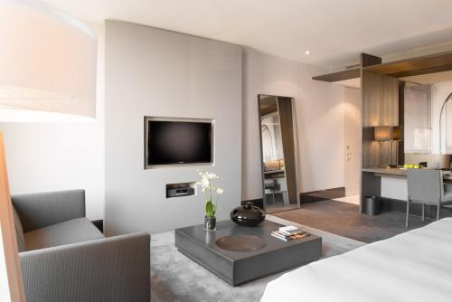 a bedroom with a bed and a living room at The Dylan Amsterdam - The Leading Hotels of the World in Amsterdam