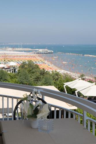 a table on a balcony with a view of a beach at Hotel Adler in Gabicce Mare