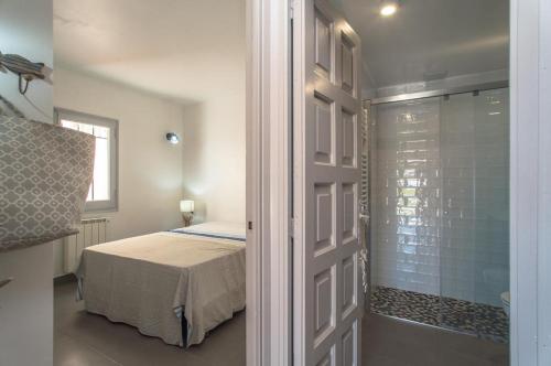 ベグールにあるST-5のベッドルーム1室(ベッド1台付)、ガラス張りのシャワーが備わります。