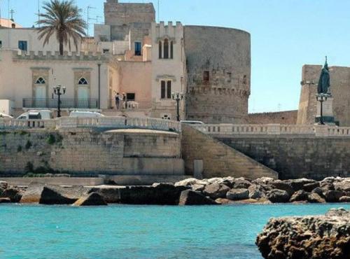 a building next to a body of water at B&B PALAZZO MARZO in Otranto