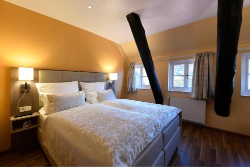 a bedroom with a large bed and two windows at Hotel Marktkieker in Großburgwedel