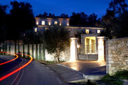 a house with lights on the side of a road at Torri E Merli Boutique Hotel in Lákka
