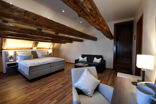- une chambre avec un lit, un canapé et une chaise dans l'établissement Hotel Marktkieker, à Großburgwedel